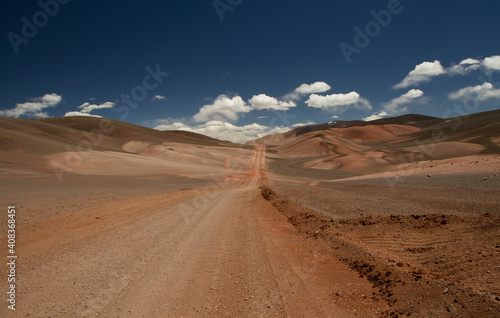 The dirt road high in the Andes mountains. Traveling along the route across the arid desert and mountain range. The sand and death valley under a deep blue sky in La Rioja, Argentina. © Gonzalo