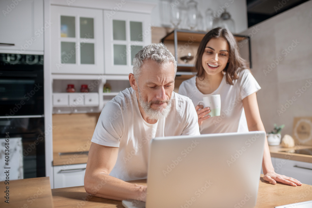 Couple checking morning emails while having coffee Couple checking morning emails while having coffee
