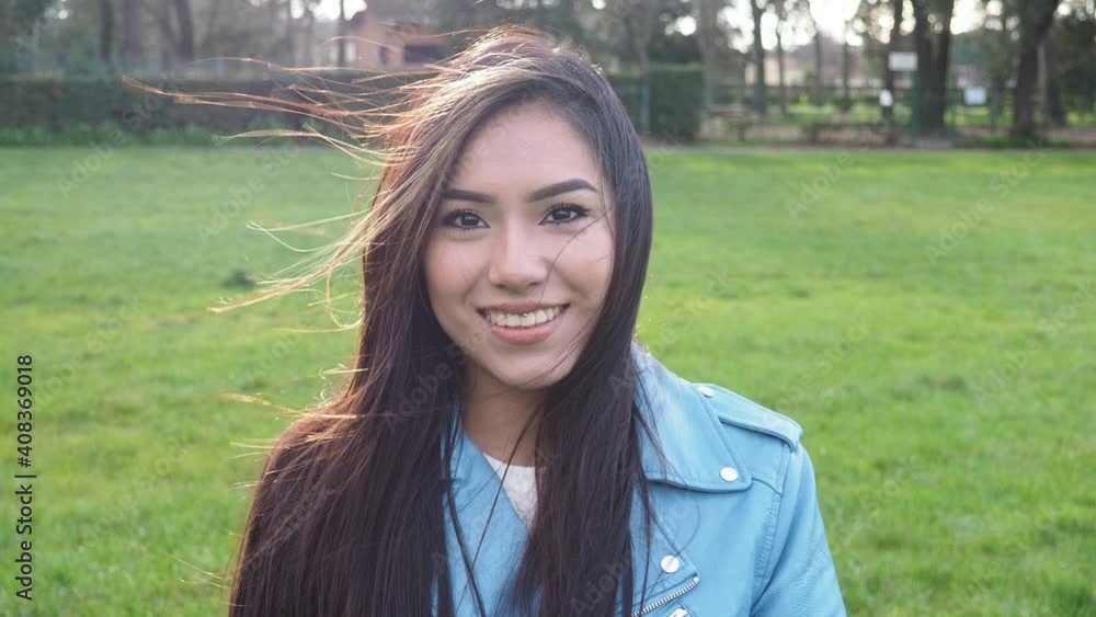 Young woman open her eyes and smiling in the winter day - Millennial having time break in the park in nature on the grass Young woman open her eyes and smiling in the winter day - Millennial having time break in the park in nature on the grass