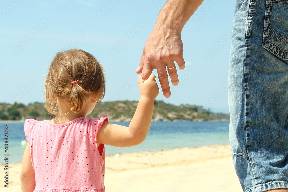 the parent holds the hand of a small child the parent holds the hand of a small child