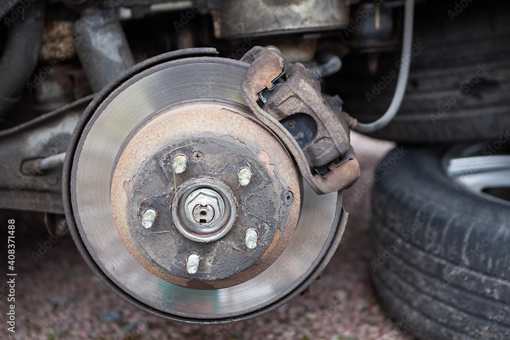 Car brake disk with removed wheel, inspection or tyre changing before winter season