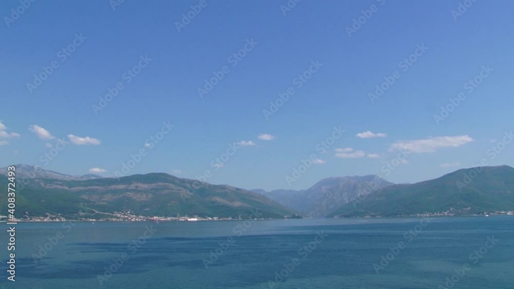 The Bay of Boka, Adriatic sea. Clean blue water and sky with some clouds and mountains in back. The Bay of Boka, Adriatic sea. Clean blue water and sky with some clouds and mountains in back.