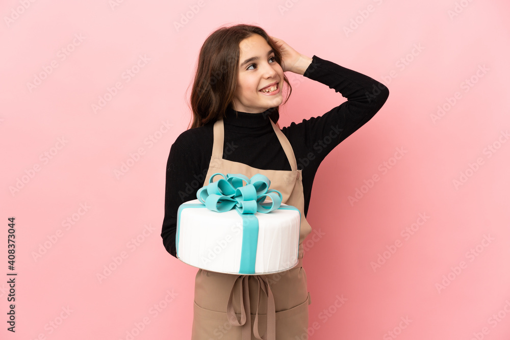 Little Pastry chef holding a big cake isolated on pink background smiling a lot Little Pastry chef holding a big cake isolated on pink background smiling a lot