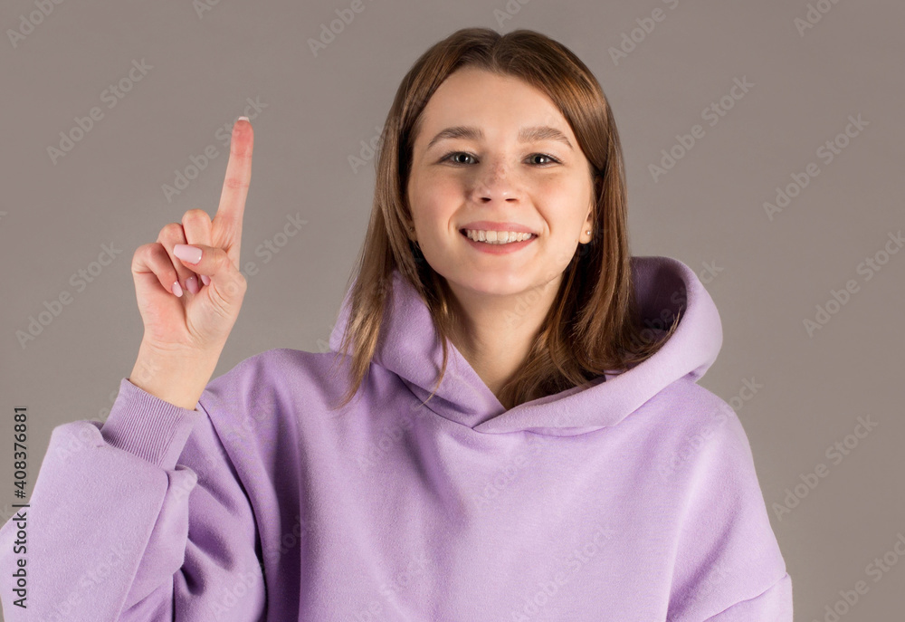 European woman with finger point up isolated on gray background European woman with finger point up isolated on gray background