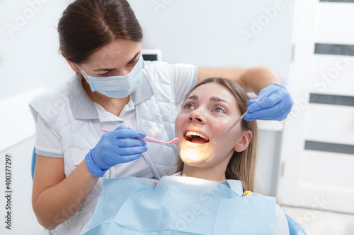 Quadro su tela Young woman getting her teeth checked by dentist