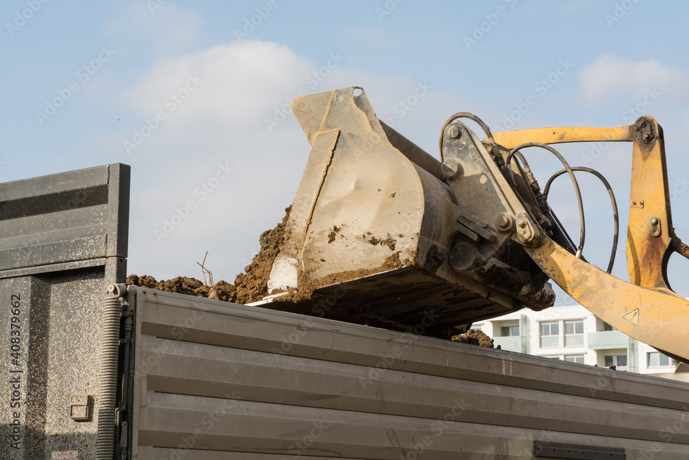 Fototapeta premium Shovel Tilts Earth In A Low Loader