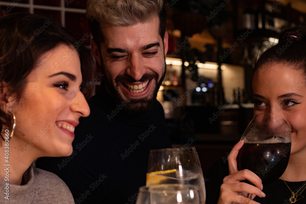 Friends enjoy themselves at a bar while having a drink, the atmosphere is youthful and fun. Friends enjoy themselves at a bar while having a drink, the atmosphere is youthful and fun.