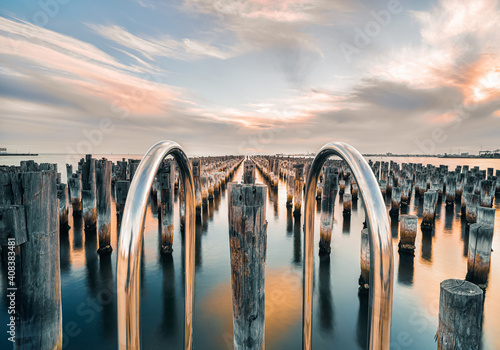 Looking into the sunset horizon of the old wooden pylons of historic princes pier in Port Melbourne, Australia.