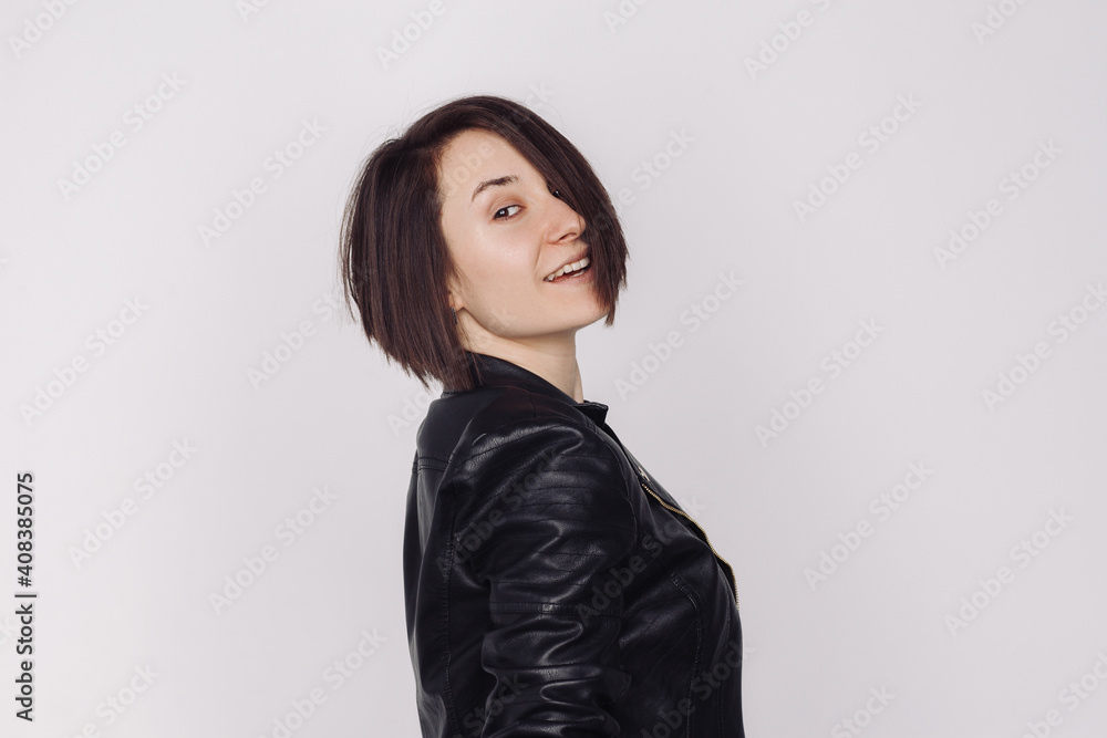 Portrait of smiling female in a black sweater and black jacket isolated on white background. Portrait of smiling female in a black sweater and black jacket isolated on white background.