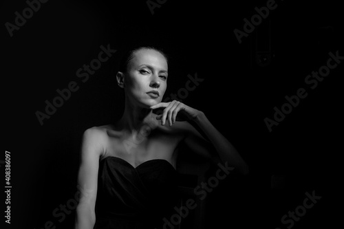 portrait of a woman in black dress with naked shoulders. Sensual portait of young 30 years old woman. black and white