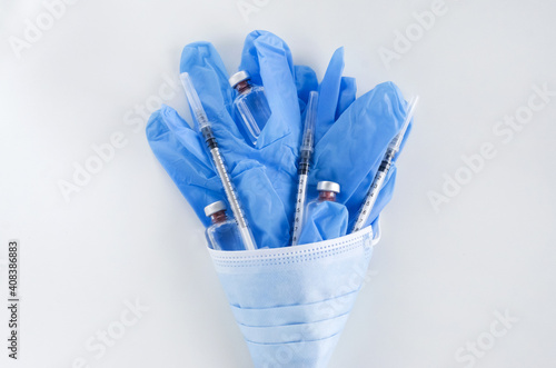 Vaccine and Healthcare Medical concept. Vaccines  medical gloves  surgical mask and syringes on white background for prevention  immunization and treatment from corona virus infection.  flat lay