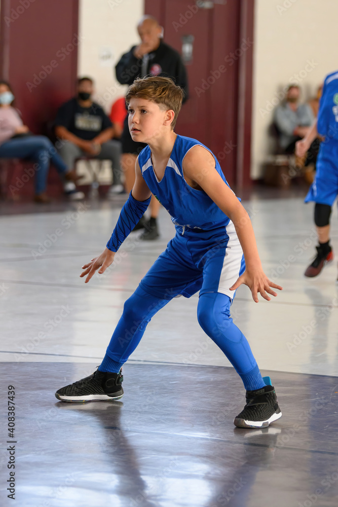 Young athletic boy playing in a game of basketball