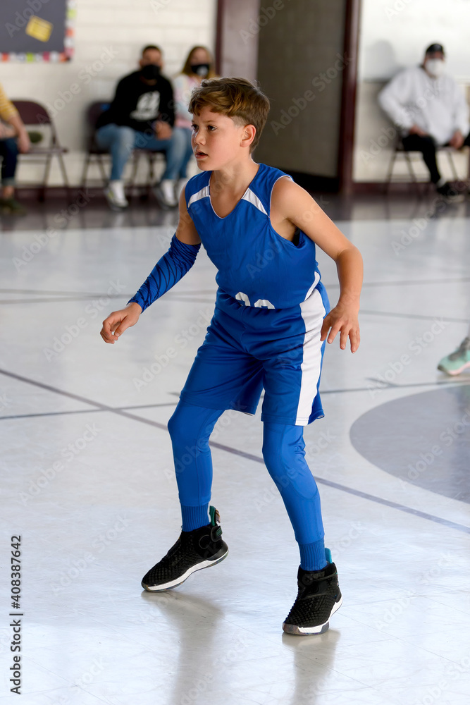 Obraz premium Young athletic boy playing in a game of basketball