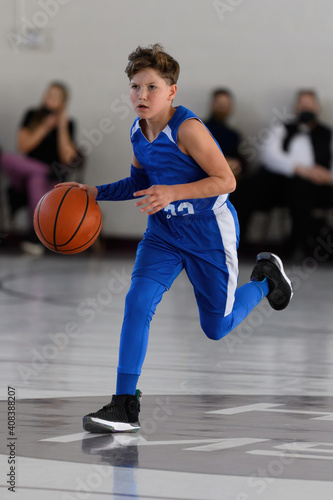 Young athletic boy playing in a game of basketball