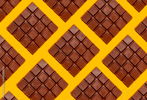 Pattern of chocolate bars against yellow background photo