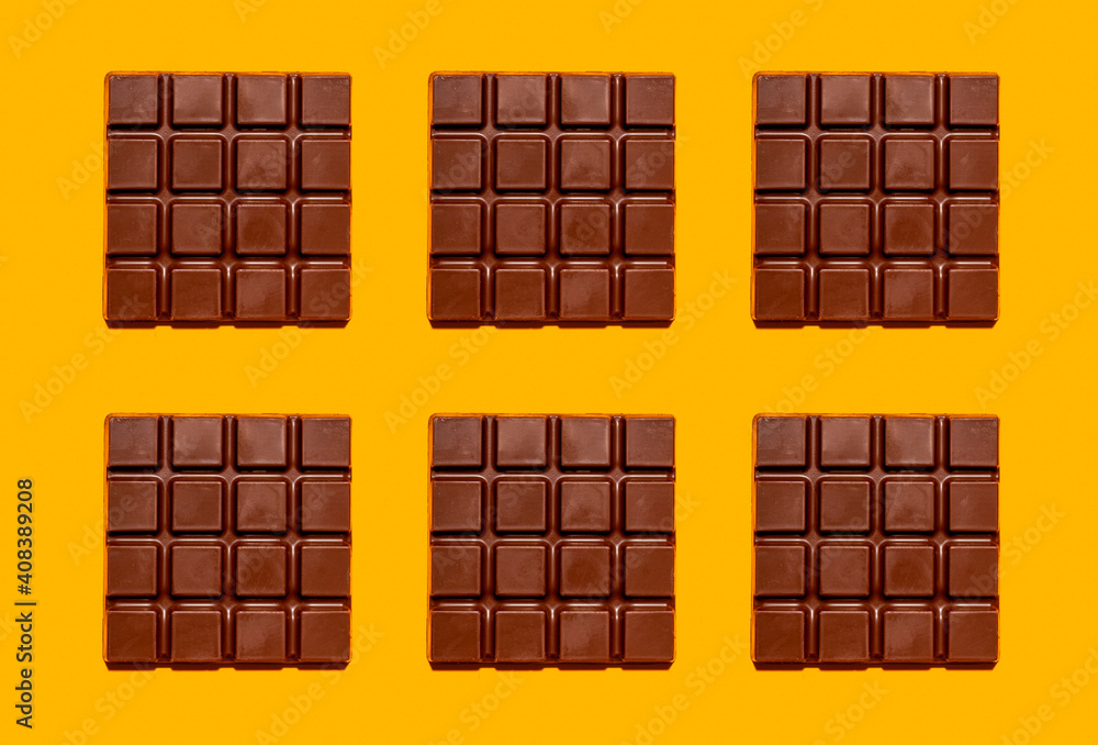 © Gemma Ferrando/Westend61 - Pattern of chocolate bars against yellow background © Gemma Ferrando/Westend61 - Pattern of chocolate bars against yellow background