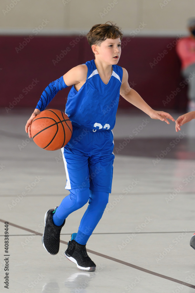 Young athletic boy playing in a game of basketball Young athletic boy playing in a game of basketball