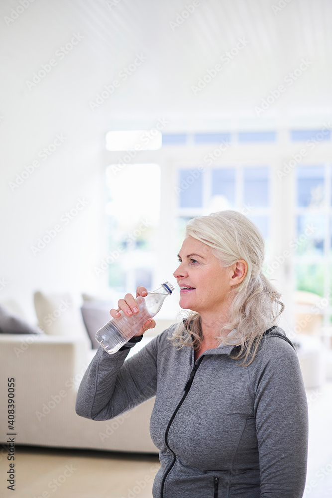 Senior woman contemplating while having water at home Senior woman contemplating while having water at home