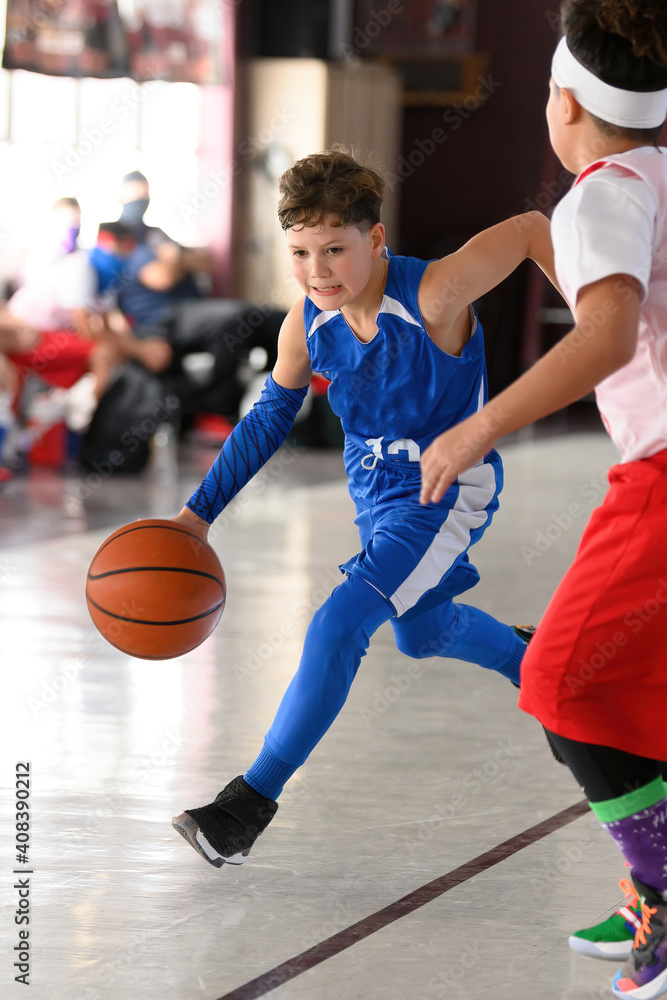 Young athletic boy playing in a game of basketball Young athletic boy playing in a game of basketball