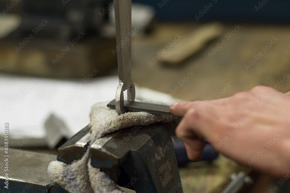 Artisan Polishes With A Flat Metal File A Piece Of Metal - Close-up Artisan Polishes With A Flat Metal File A Piece Of Metal - Close-up