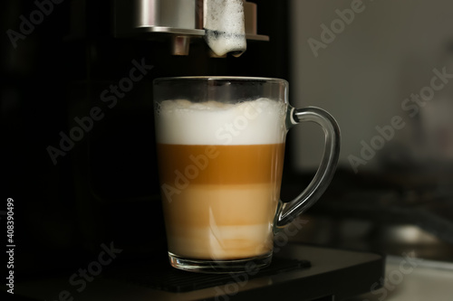 Making coffee in a coffee machine at home. Boil and beat process. The finished coffee has three layers of white, beige and brown. Layering. Coffee with milk.