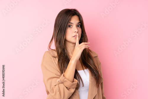 Teenager Brazilian girl over isolated pink background doing silence gesture © luismolinero