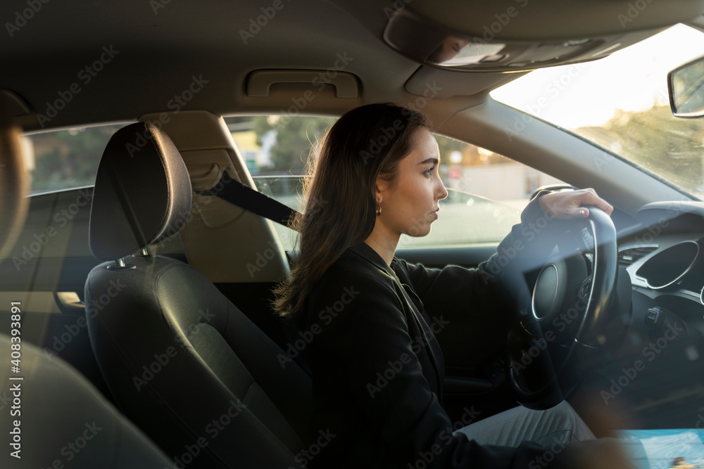Young businesswoman looking away while driving car