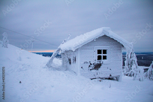Hidden Santas cottage covered in snow in the ski slopes on the mountain at Levi ski center, Kittilä, Finland.