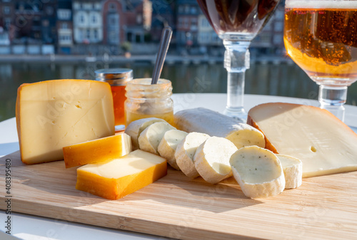 Cheese collection, Belgian abbey cheeses made with brown trappist beer and fine herbs and view on Maas river in Dinant, Wallonia, Belgium photo