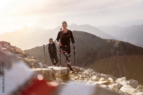 Sportsman and woman with hiking pole and backpack walking on mountain path of Bschiesser at Tyrol, Austria