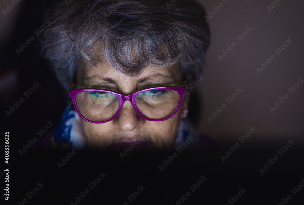 Close-up of teacher with gray hair working over laptop at home Close-up of teacher with gray hair working over laptop at home