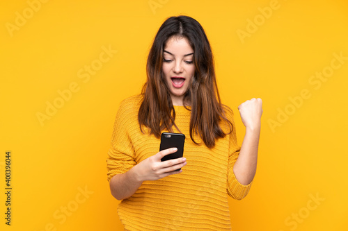 Young caucasian woman isolated on yellow background surprised and sending a message