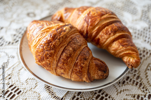 Two fresh baked puff croissants, traditional French breakfast