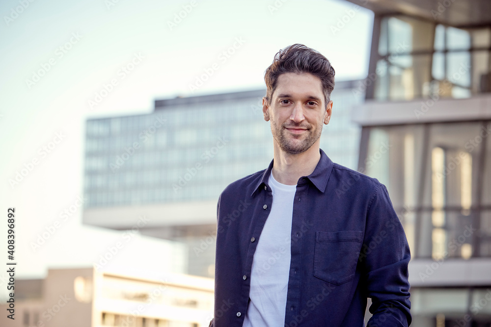 Businessman smiling while standing in city Businessman smiling while standing in city