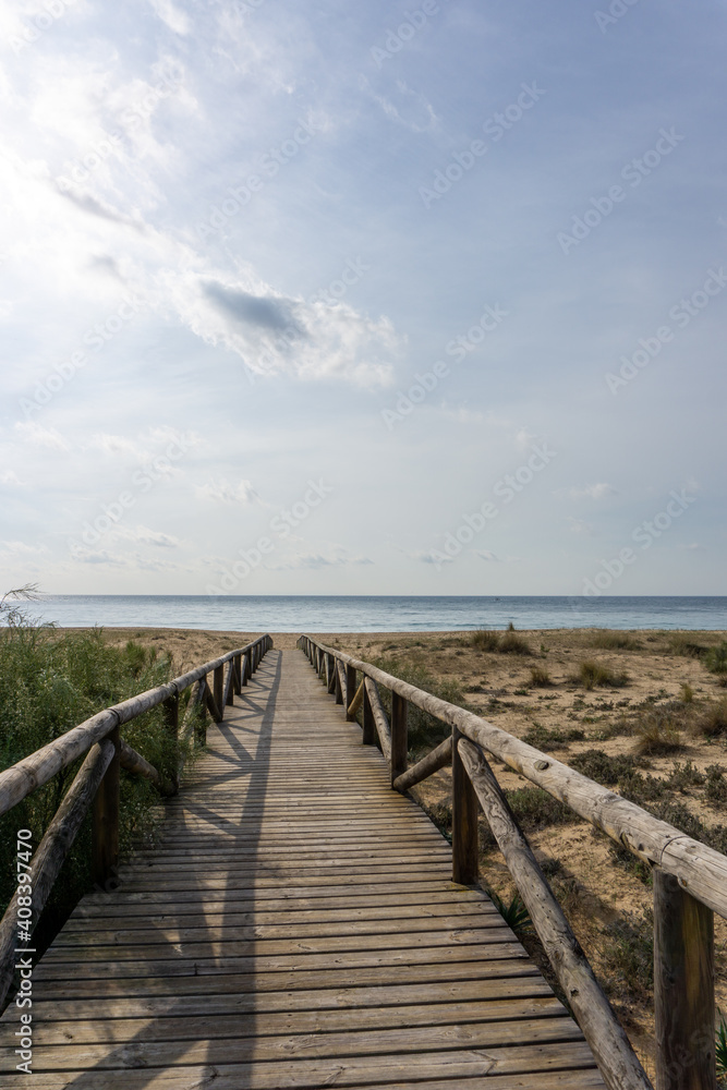 Fototapeta long wooden boardwalk and beach access leads to beach and glistening ocean