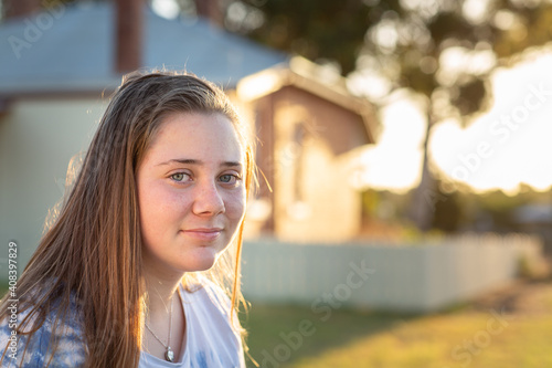 Teenage girl backlit outside a home photo