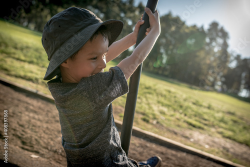 5 year old mixed race boy plays outdoors in a playground photo