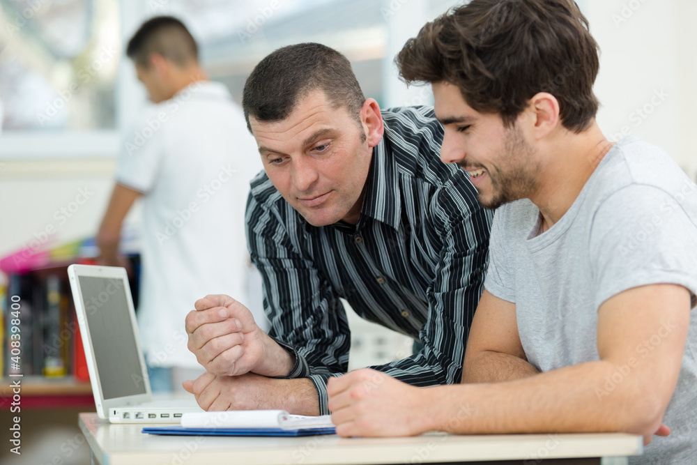 student discussing with teacher in classroom student discussing with teacher in classroom