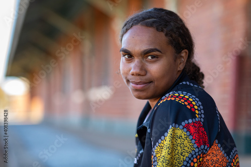 head and shoulders of young aboriginal woman with hair tied back photo