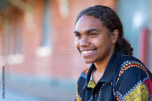 head and shoulders of smiling teenager with hair tied back