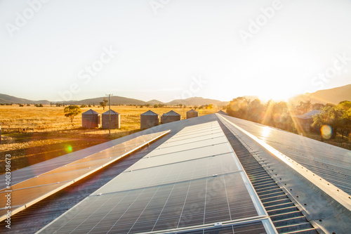 Solar panels on a shed roof generating energy with sunlight lens flare photo