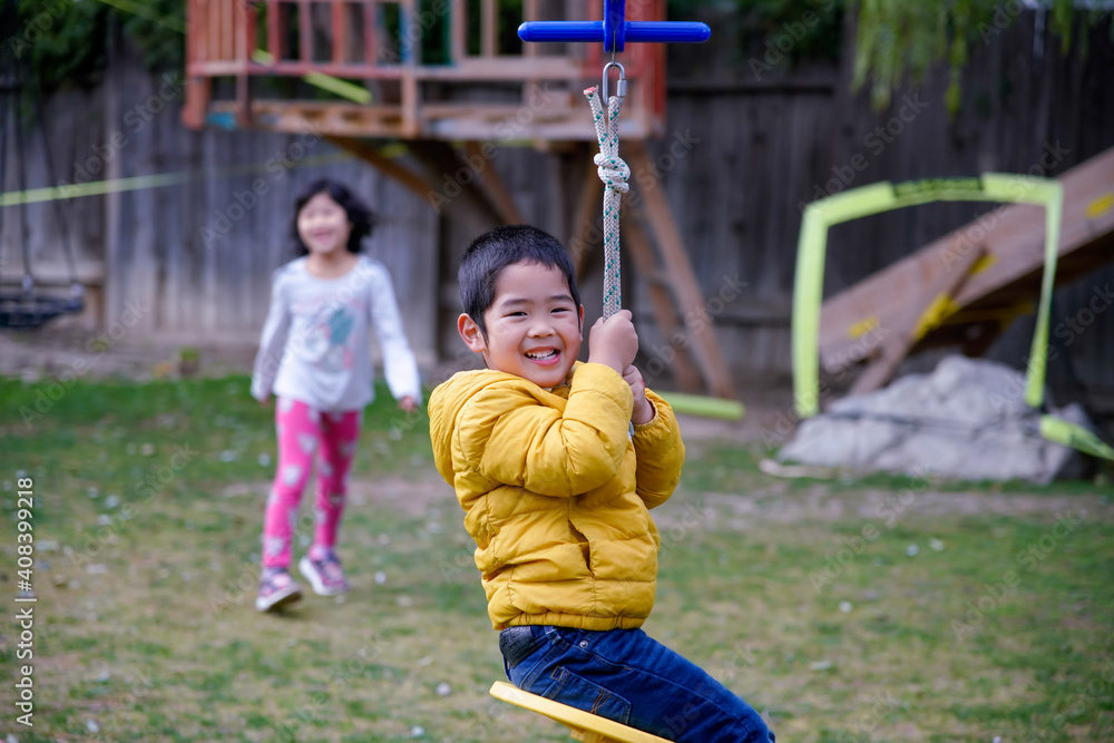 The boy playing zip lining in the backyard The boy playing zip lining in the backyard