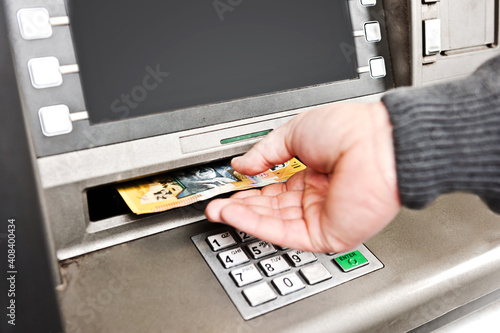 Man's hand at the ATM, with money