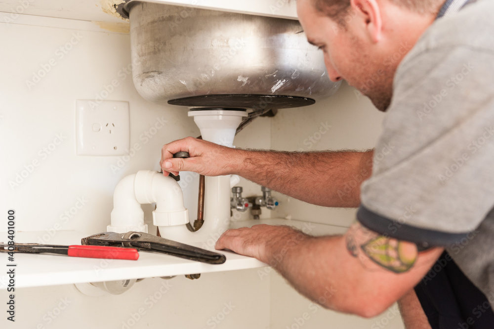 Plumber installing a sink and pipes Stock Photo Adobe Stock