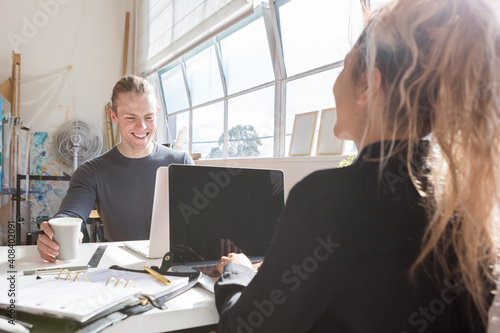Coworkers at a shared desk in a creative studio workplace photo