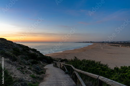 boardwalk leading to a calm beautiful beach at sunset