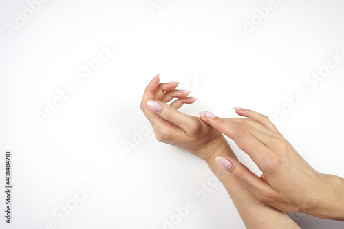 Classic pink manicure. Young woman s hands on peach and white background.