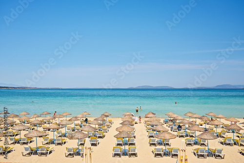 Fototapeta Naklejka Na Ścianę i Meble -  Empty sunbeds on ilica beach by the open sea, Cesme