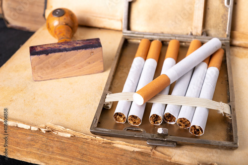 Wooden stamp for stamping and cigarettes in a metal cigarette case. Office accessories in the old office. photo