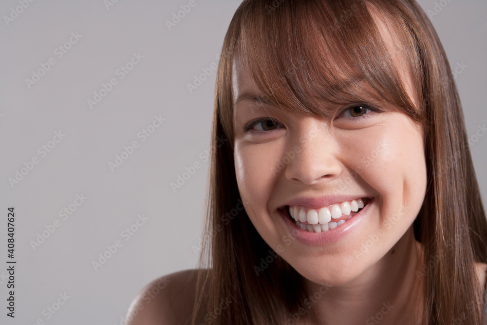 Portrait of young smiling woman, studio shot